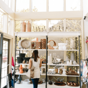 woman browses items at a bright and airy home decor boutique