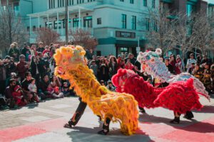 chinese dragon dancers perform in front of a crowd
