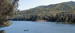 two people row a canoe at lake del valle regional park
