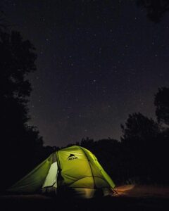 illuminated tent under a dark starry night
