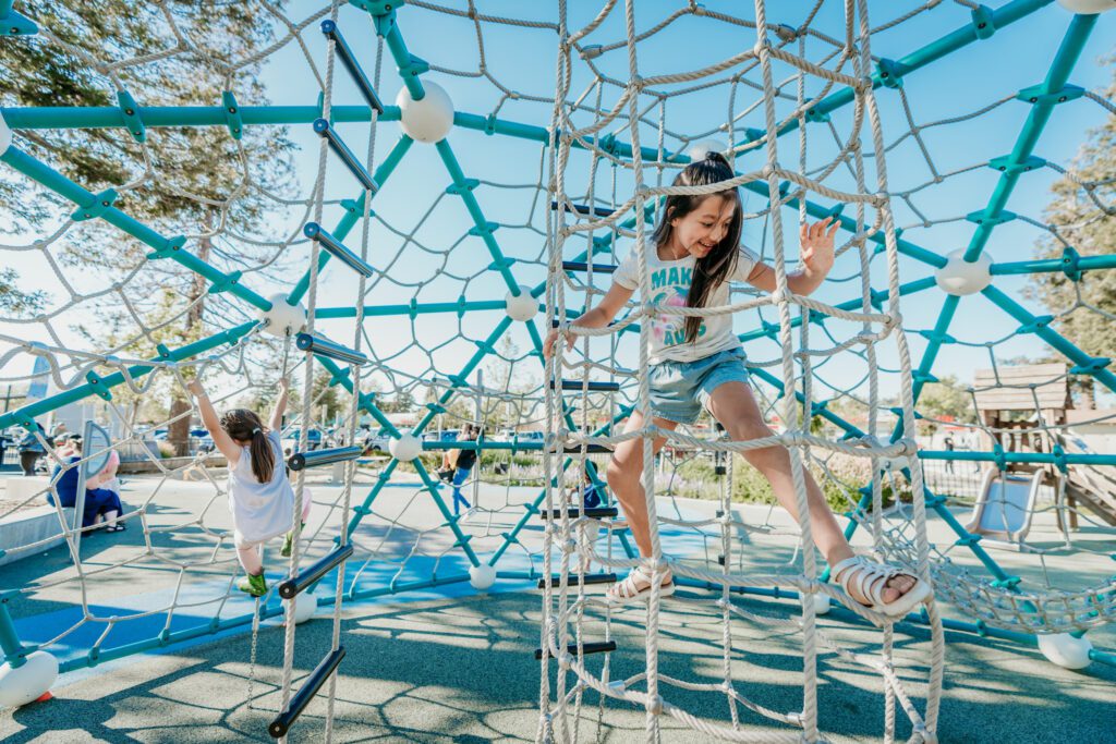 kids playing on climbing structure at park
