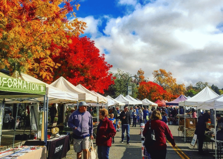 colorful fall trees surround a farmers market in downtown pleasanton