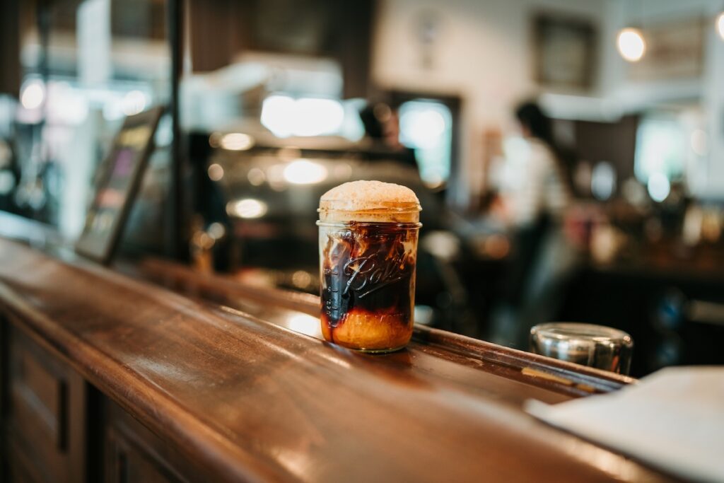 close-up of a foamy coffee beverage on an elegant wooden bar