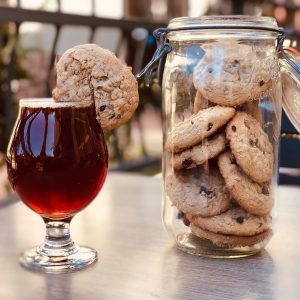 spiced beer with oatmeal cookie on the rim and a jar of cookies